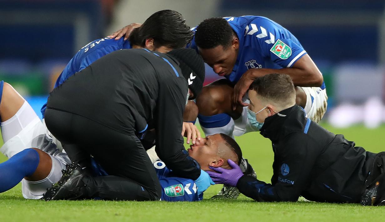 Striker Everton, Richarlison, mendapat perawatan dari tim medis usai terlibat benturan dengan bek Manchester United, Eric Bailly, dalam laga perempatfinal Piala Liga Inggris Carabao Cup di Goodison park, Rabu (23/12/2020). Everton kalah 0-2 dari Manchester United. (AFP/Nick Potts/Pool)