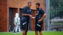 Pelatih kepala Timnas Indonesia, Patrick Kluivert (kiri) berdiskusi dengan asisten pelatih Denny Landzaat saat melakukan latihan persiapan menjelang laga Ronde 3 Kualifikasi Piala Dunia 2026 melawan China di Bali United Training Center, Bali, pada Selasa sore (23/05/2025). (Bola.com/Alit Binawan)