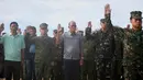 Menteri Pertahanan Delfin Lorenzana bersama Tentara Filipina saat mengikuti upacara pengibaran bendera di Pulau Thitu, Kepulauan Spratly, Laut China Selatan, Jumat (21/4). (AP Photo / Bullit Marquez)