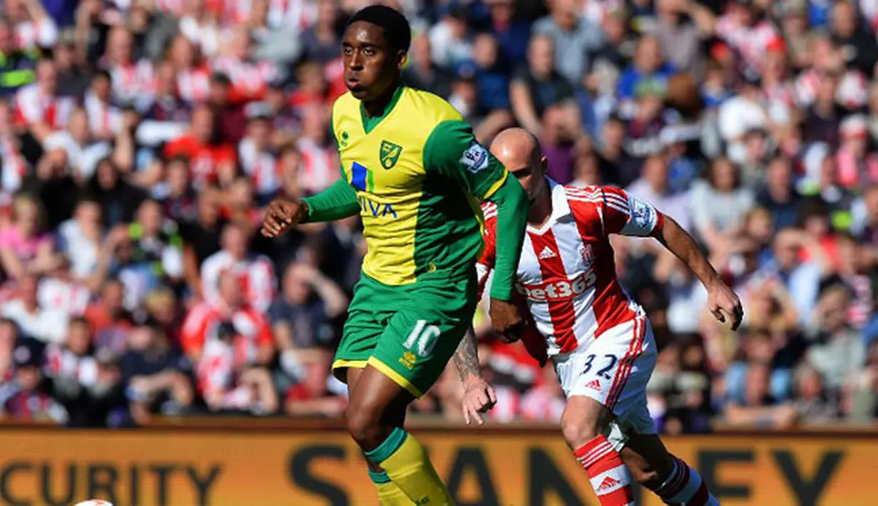 Gelandang Norwich City Leroy Fer (kiri) berhasil melewati gelandang Stoke City Irish Stephen Ireland (kanan) pada pertandingan sepak bola Liga Inggris antara Stoke City vs Norwich City di Stadion Britannia (29/09/13). (AFP/Paul Ellis)