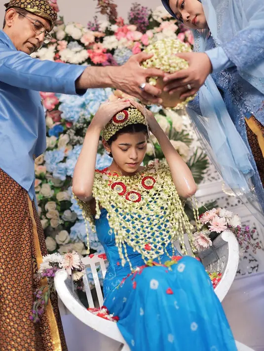 Ia tak kalah memesona dibalut kain batik berwarna biru dipadukan dengan rompi dan bandana roncean melati. [@jharnabhagwani]