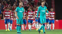 Reaksi gelandang Barcelona, Ivan Rakitic (kiri) dan rekannya, Gerard Pique setelah pemain Granada, Ramon Azeez mencetak gol pada laga pekan kelima La Liga di Stadion Nuevo Los Cármenes, Sabtu(21/9/2019). Barcelona tumbang dalam lawatannya ke markas tim promosi, Granada 0-2. (JORGE GUERRERO/AFP)
