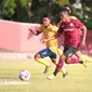 Bek kiri Persis Solo, Gufroni Al Ma'ruf (seragam merah) saat ditempel pemain Persika Karanganyar dalam uji coba di Stadion UNS, Surakarta, Rabu (7/10/2020). (Bola.com/Vincentius Atmaja)