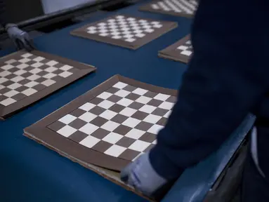 Seorang karyawan Rechapados Ferrer membuat papan catur di La Garriga dekat Barcelona (5/3/2021). Penjualan pembuat papan catur Spanyol itu melonjak sejak ditampilkan di serial Netflix terkenal "The Queen's Gambit". (AFP Photo/Josep Lago)