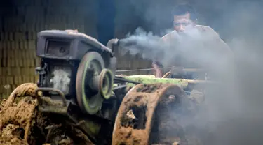 Seorang pria mencampur bahan untuk membuat batu bata di sebuah pabrik batu bata di pinggiran Kajhu, Provinsi Aceh (18/11/2020). (AFP/Chaideer Mahyuddin)