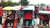 Bakal calon (balon) Gubernur-Wagub Sumsel Eddy Santana Putra-Riezky Aprilia didampingi Ketua PDI Perjuangan Sumsel Giri Ramandha saat mendaftarkan diri maju Pilgub Sumsel ke KPU Sumsel menggunakan becak (Liputan6.com / Nefri Inge)