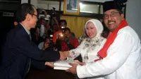 Pasangan bakal calon Gubernur dan Wagub, Atut Chosiyah dan Rano Karno menyerahkan berkas pendaftaran ke petugas KPUD Banten, di Serang, Kamis (14/7) malam. (Antara)