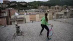 Vittoria Oliveri (depan) bermain tenis dengan Carola di atas atap rumah mereka selama lockdown COVID-19 di Finale Ligure, Wilayah Liguria, Italia (19/4/2020). Setiap hari Carola, 11, dan Vittoria, 13, bermain tenis dari satu atap ke atap lain di rumah mereka untuk berlatih. (AFP/Marco Bertorello)