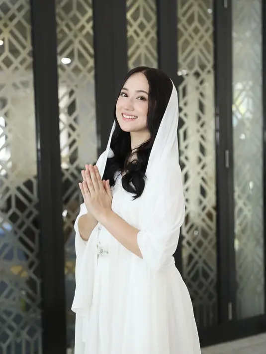 Pesona luar biasa Laura Moane dibalut gamis putih. Rambutnya ditutupi dengan syal putih polos yang serasi. [Foto: Instagram/its_lauramoane2]