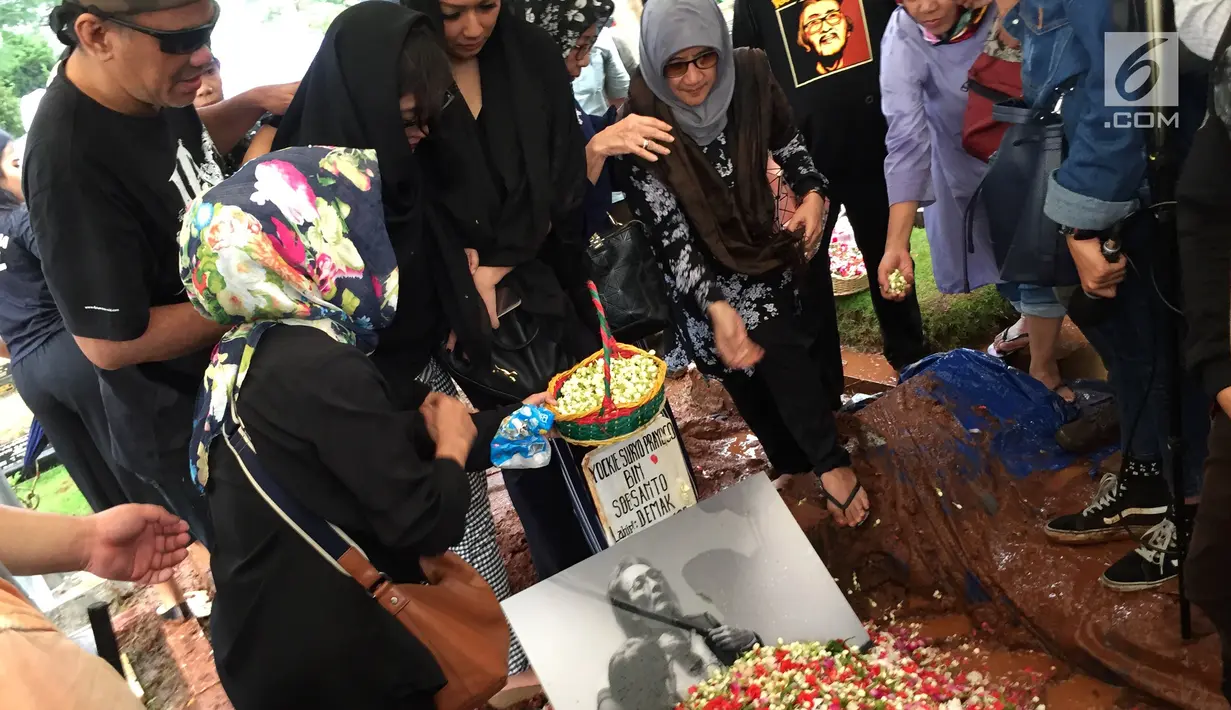 Keluarga menaburkan bunga di atas pusara Yockie Suryo Prayogo di TPU Karet Bivak, Jakarta, Senin (5/2). (Liputan6.com/Immanuel Antonius)