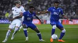 Gelandang Real Madrid Federico Valverde berebut bola dengan pemain Al Hilal Khalifah Aldawsari dan Ali Albulayhi dalam partai final Piala Dunia Antarklub 2022 di Prince Moulay Abdellah Stadium, Rabat, Minggu (12/2/2023) dini hari WIB. Federico Valverde dan Vinicius Junior masing-masing memborong dua gol, sedangkan Karim Benzema turut menyumbang satu gol. (AP Photo/Manu Fernandez)