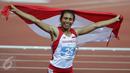 Atlet putri Indonesia, Maria Londa membentangkan Merah Putih usai memastikan meraih emas cabang atletik nomor lompat jangkit di National Stadium, Singapura, Kamis (11/6/2015). Maria mencatat lompatan sejauh 13,75 meter. (Liputan6.com/Helmi Fithriansyah)
