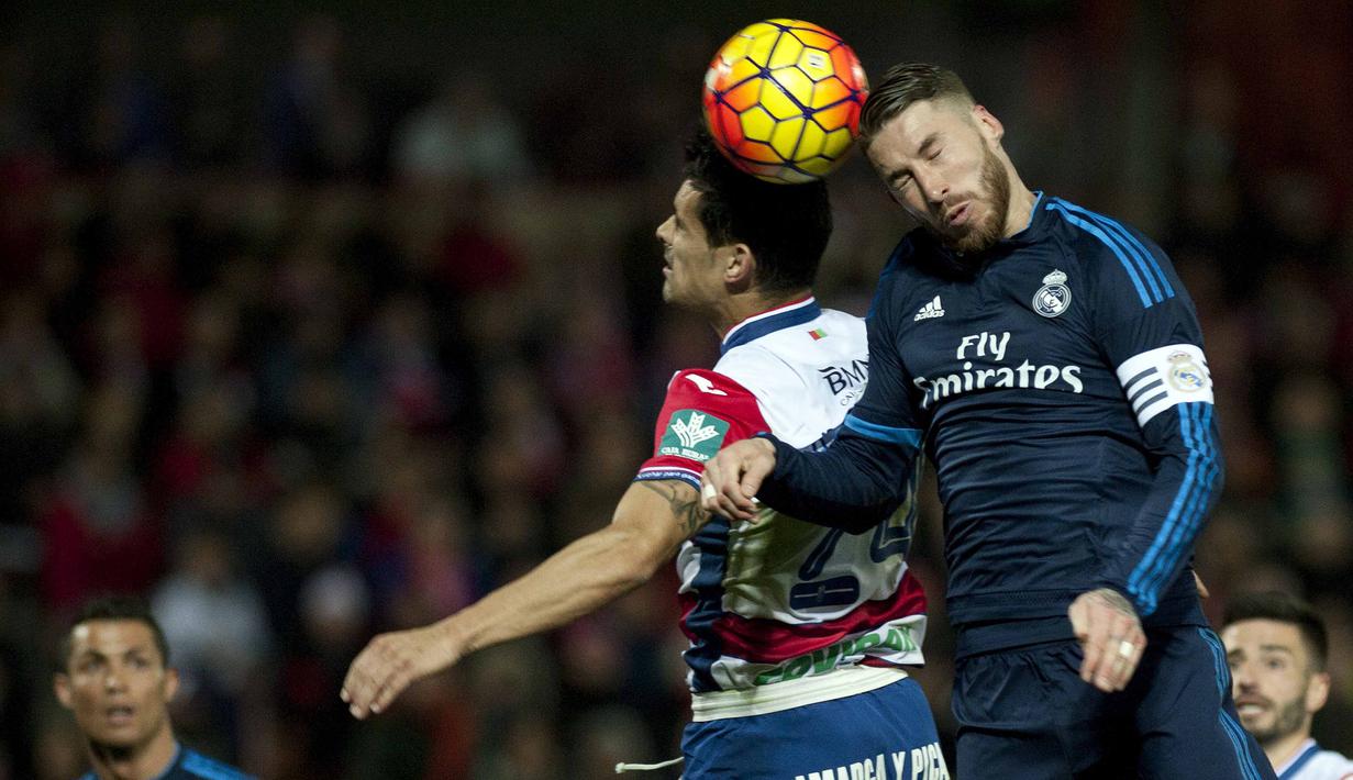 Pemain Granada, Ricardo Costa (kiri) berebut bola dengan pemain Real Madrid, Sergio Ramos pada lanjutan La Liga Spanyol di di Estadio Nuevo Los Carmenes, Senin (8/2/2016) dini hari WIB. (AFP/Jorge Guerrero)