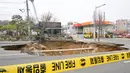 Insiden sinkhole atau lubang runtuhan terjadi di jalan sekitar daerah Myeongil-dong, distrik Gangdong-gu, kota Seoul pada pukul 18:30 waktu setempat pada Senin (24/3/2025) kemarin. (Anthony WALLACE/AFP)