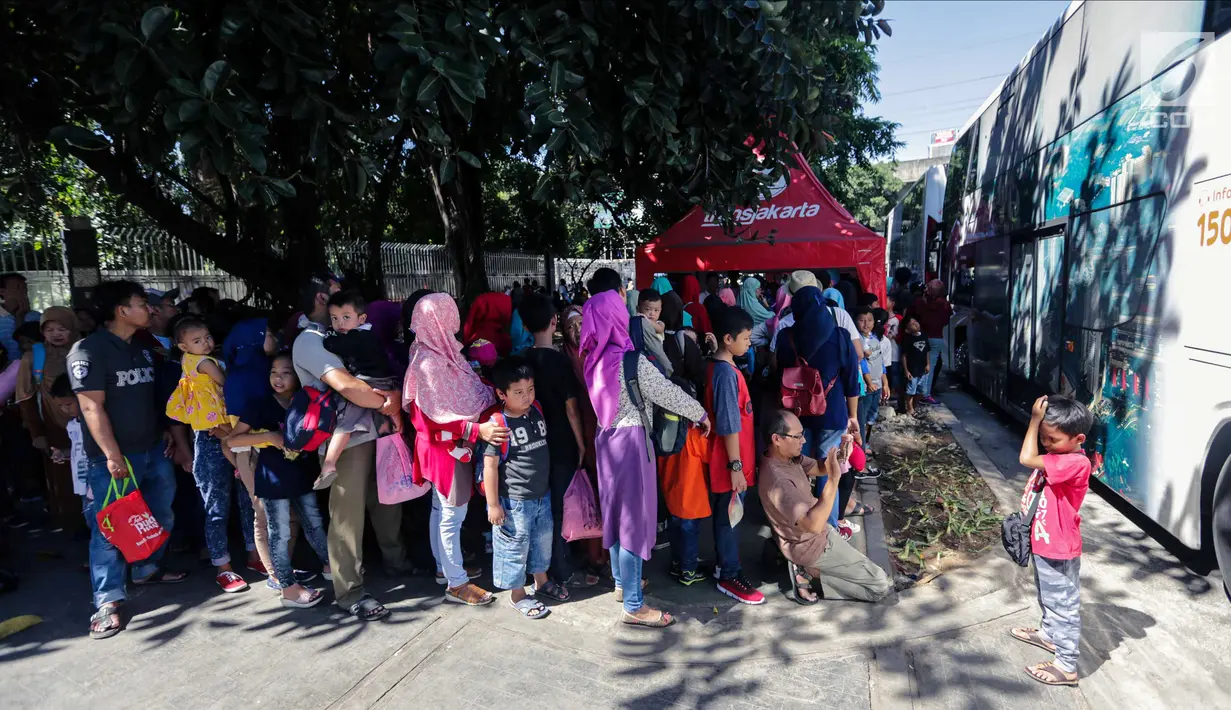 Sejumlah warga mengantre untuk menaiki bus City Tour di kawasan Masjid Istiqlal, Jakarta, Senin (25/12). Mayoritas warga menggunakan moda transportasi massal ini menuju kawasan Kota Tua. (Liputan6.com/Faizal Fanani)