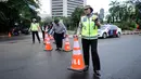 Petugas gabungan memasang tanda saat pengalihan arus di Jalan Jenderal Sudirman, Jakarta, Minggu (31/12). Pengalihan terkait malam puncak perayaan pergantian tahun di kawasan Bundaran HI hingga Jalan MH Thamrin. (Liputan6.com/Helmi Fithriansyah)
