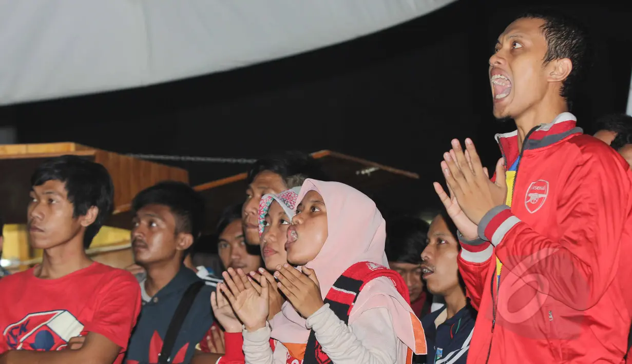 supporter Arsenal saat  menyaksikan tim kesayangannya bertanding saat nonton bola seru Manchester United vs Arsenal di Karawang Central Plaza, Minggu (17/5/2015). Laga antara Manchester United dan Arsenal berakhir imbang. (Liputan6.com/Helmi Afandi)