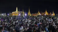 Demonstran pro-demokrasi menghadiri protes di Sanam Luang dengan The Grand Palace menyala di latar belakang di Bangkok, Thailand (19/9/2020). (AP Photo/Sakchai Lalit)