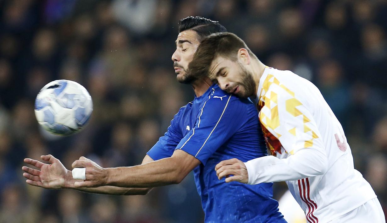Pemain Italia, Graziano Pelle (kiri), berebut bola dengan pemain Spanyol, Gerard Pique, dalam laga persabatan di Stadion Friuli, Udine, Italia. (24/3/16). (Reuters/Alessandro Garofalo)