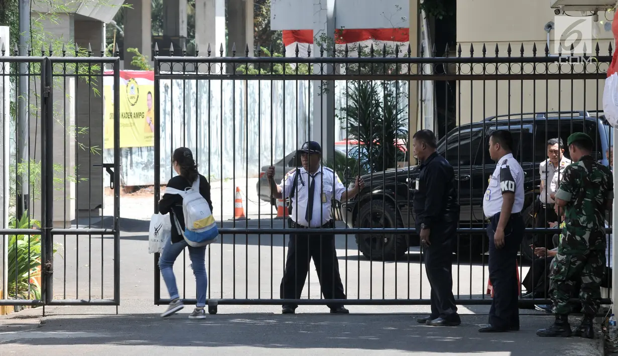 Sejumlah petugas gabungan polisi, tentara, dan satpam berjaga di gerbang pintu masuk Kantor DPP Partai Golkar, Slipi, Jakarta, Rabu (21/8/2019). Penjagaan ketat dilakukan setelah sehari sebelumnya ratusan orang berseragam Angkatan Muda Partai Golkar menduduki kantor itu. (merdeka.com/Iqbal Nugroho)