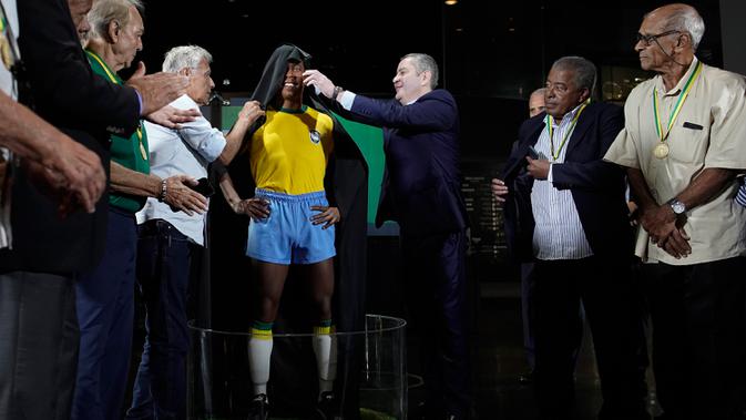 Presiden CBF Rogerio Caboclo membuka penutup patung legenda sepak bola Brasil, Pele, di Museum Tim Sepak Bola Brasil di Rio de Janeiro, Kamis (20/2/2020). Konfederasi Sepak Bola Brasil meluncurkan patung Pele sebagai bagian dari peringatan 50 tahun sejak kemenangan Piala Dunia 1970. (AP/Leo Correa)