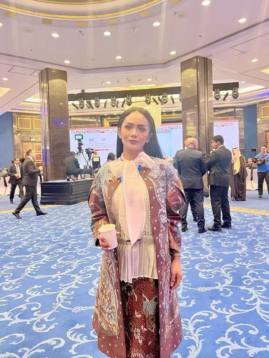 Potret lainnya memperlihatkan KD yang tampil menawan mengenakan outer dan blus putih beraksen pita besar. [Foto: IG/krisdayantilemos].