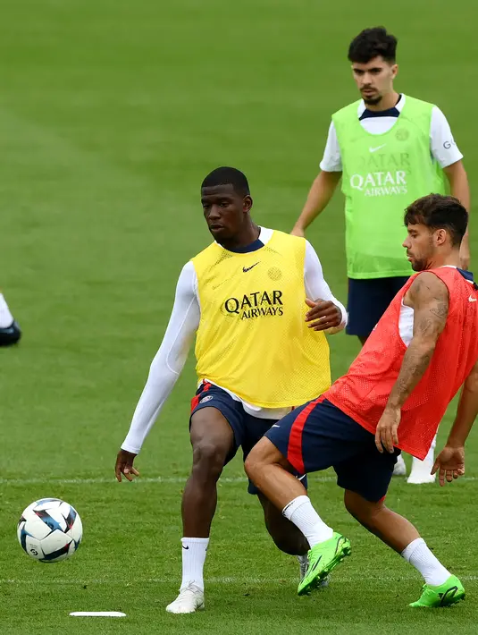 Bek Paris Saint-Germain (PSG) Nordi Mukele (kiri) berebut bola dengan Juan Bernat (kanan) selama  sesi latihan jelang melawan Monaco, di Saint-Germain-en-Laye, barat Paris pada 26 Agustus 2022. Laga PSG vs AS Monaco di lanjutan Ligue 1 Prancis akan berlangsung pada 29 Agustus 2022 dinihari WIB. (FRANCK FIFE / AFP)