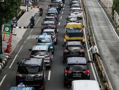 Seorang warga menyeberang jalan saat sejumlah kendaraan terjebak kemacetan di kawasan Jalan Buncit Raya, Jakarta Selatan, Rabu (11/5/2022). Sejumlah ruas jalan Ibu Kota kembali mengalami kemacetan karena meningkatnya volume kendaraan usai libur Lebaran. (Liputan6.com/Johan Tallo)