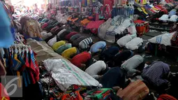 Sejumlah umat muslim saat melakukan shalat Jumat di tengah-tengah barang jualannya, Tanah Abang , Jakarta, Jumat (26/6/2015). Hal ini dilakukan untuk menghindari incaran tangan-tangan jahil . (Liputan6.com/Johan Tallo)