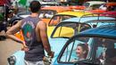 Peserta berbincang saat mengikuti ajang pertemuan tahunan "Beetle club" di Yakum, Israel tengah (21/4). Volkswagen Beetle ini diproduksi mulai tahun 1938 sampai 2003, dengan bentuk yang khas. (AP Photo / Oded Balilty)