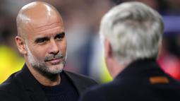 Pelatih Manchester City, Pep Guardiola bersalaman dengan pelatih Real Madrid, Carlo Ancelotti dalam laga leg 2 play off Liga Champions 2024/2025 di Santiago Bernabeu, Madrid, Spanyol, Rabu (20/02/2025) waktu setempat. (AP Photo/Manu Fernandez)