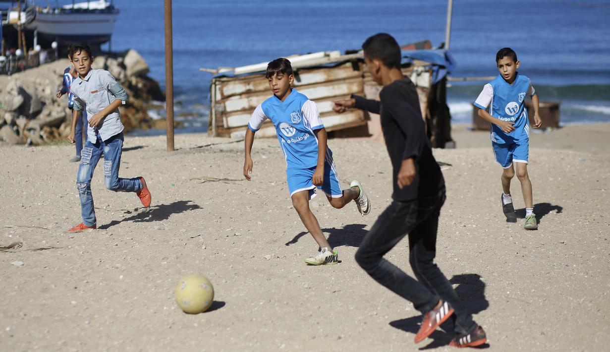 Sejumlah anak Palestina bermain sepak bola di kawasan Gaza, Jumat (3/11/2017). Sepak bola tidak hanya menjadi olahraga favorit, tapi juga sebagai salah satu cara bagi warga untuk mengurangi ketegangan akibat peperangan. (AFP/Mohammed Abed)
