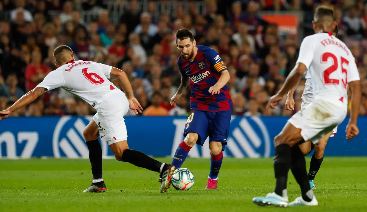 Bintang Barcelona, Lionel Mess mengontrol bola dibayangi pemain Sevilla dalam pertandingan pekan kedelapan kompetisi La Liga Spanyol 2019-2020 di Camp Nou, Minggu (6/10/2019). Barcelona berhasil menang telak atas Sevilla dengan skor 4-0. (AP Photo/Joan Monfort)