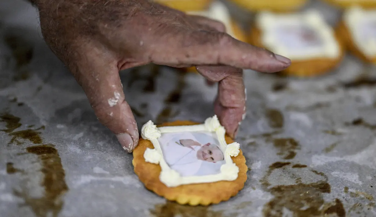 Seorang pastry membuat kue dengan gambar Paus Fransiskus di toko kue Balcao do Marques di Lisbon pada 28 Juli 2023. Portugal sedang mempersiapkan diri untuk menyambut Paus Fransiskus dan sekitar satu juta peziarah muda untuk World Youth Day (WYD) pada 2 hingga 6 Agustus 2023.
(Patricia DE MELO MOREIRA / AFP)