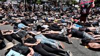 Anggota komunitas LGBTQ bersama pengunjuk rasa Black Lives Matter melakukan aksi tiarap di jalan dengan tangan seolah terikat di West Hollywood, California, Rabu (3/6/2020). Aksi menyimbolkan momen terakhir George Floyd saat lehernya ditindih lutut polisi Minneapolis pada 25 Mei. (AP/Richard Vogel)