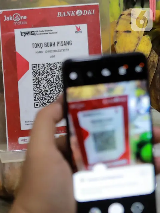 QRIS adalah standar kode QR (Quick Response) yang digunakan di Indonesia untuk menghubungkan dompet digital dan metode pembayaran non-tunai dengan berbagai pihak, termasuk bank dan pedagang. (Liputan6.com/Johan Tallo)