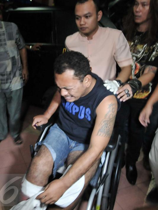 Alfin Bernius Sinaga tampak meringis kesakitan saat tiba di RS Polri, Kramatjati, Jakarta Timur, Kamis (29/12). Alfin diduga ikut terlibat dalam perampokan disertai penyekapan yang mengakibatkan 6 orang tewas. (Liputan6.com/Yoppy Renato) 