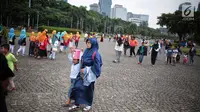 Sejumlah pengunjung berjalan-jalan di kawasan Monumen Nasional (Monas), Jakarta, Sabtu (22/12). Libur sekolah yang berbarengan dengan libur Natal dan Tahun Baru dimanfaatkan masyarakat untuk pergi berwisata ke Monas. (Liputan6.com/Faizal Fanani)