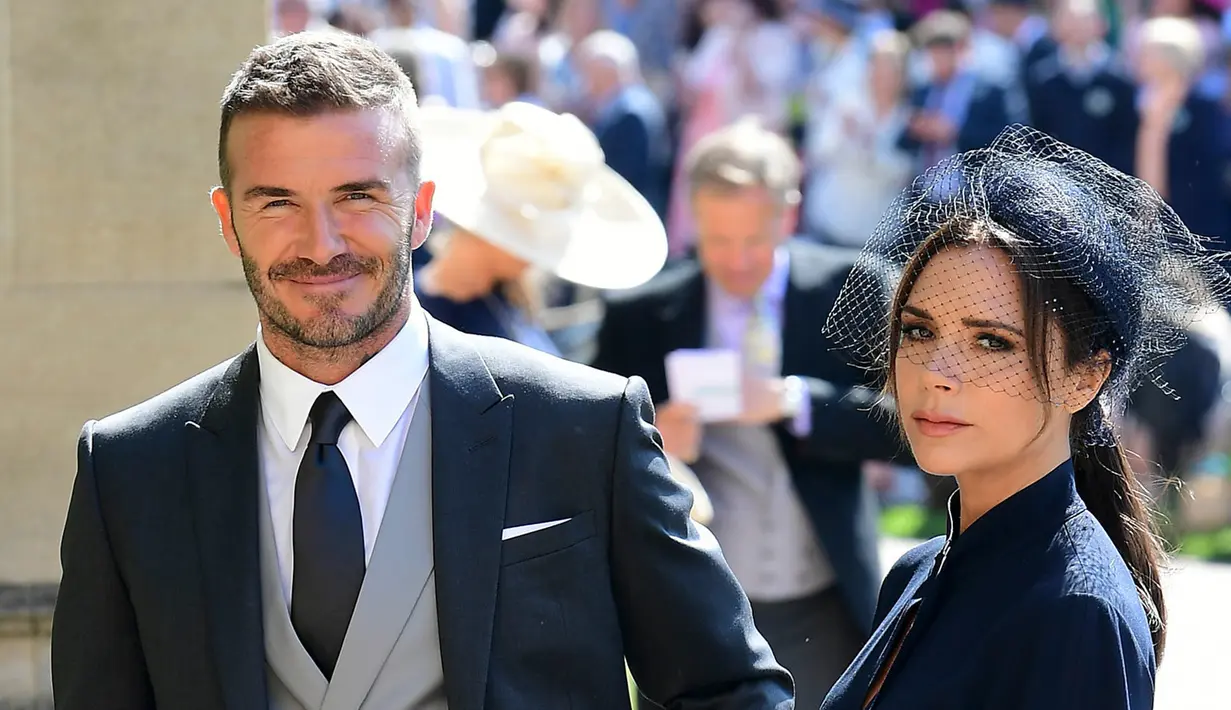 <p>Senyum mantan pemain sepak bola Inggris, David Beckham dan sang istri Victoria Beckham saat menghadiri pernikahan Pangeran Harry dan Meghan Markle di St. George's Chapel, Kastil Windsor, Inggris, Sabtu (19/5). (IAN WEST/POOL/AFP)</p>