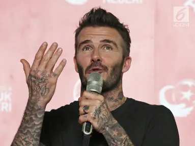 Mantan bintang sepak bola Inggris David Beckham memberikan sambutan pada acara AIA Sepak Bola untuk Negeri di Jakarta, Minggu (25/3). David Beckham tampil dengan kaos hitam dan badan penuh tato. (Liputan6.com/Herman Zakharia)