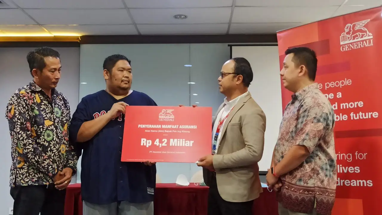 Head of Corporate Communications, PT Asuransi Generali Indonesia Windra Krismansyah memberikan tanda simbolis pembayaran manfaat asuransi senilai Rp 4,2 miliar kepada perwakilan keluarga nasabah, Agus Hariyanto. (Dok Generali)