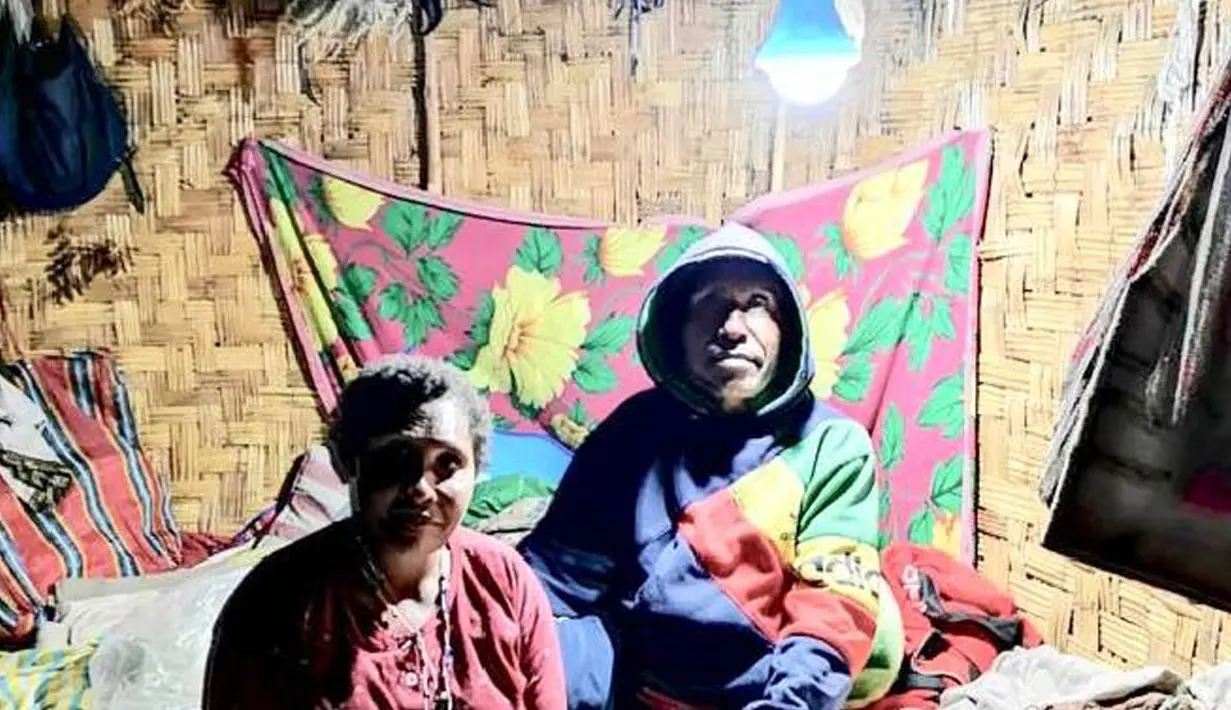 Warga duduk di bawah lampu listrik di Distrik Puldama, Kabupaten Yahukimo, Provinsi Papua. Jelang HUT ke-73 RI, untuk pertama kalinya warga Puldama menikmati lampu listrik di rumah mereka. (Liputan6.com/HO/Hadi M Juraid)