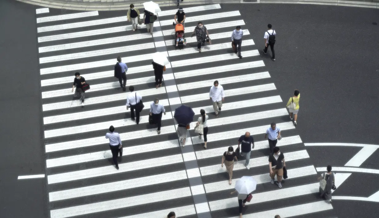 Orang-orang berjalan melintasi persimpangan dekat Stasiun Tokyo di Tokyo sehari setelah kasus virus corona tertinggi ditemukan di kota tuan rumah Olimpiade Kamis (29/7/2021). Tokyo telah melaporkan jumlah tertinggi infeksi Covid-19 hanya beberapa hari setelah dimulainya Olimpiade. (AP/Kntaro Komiya)
