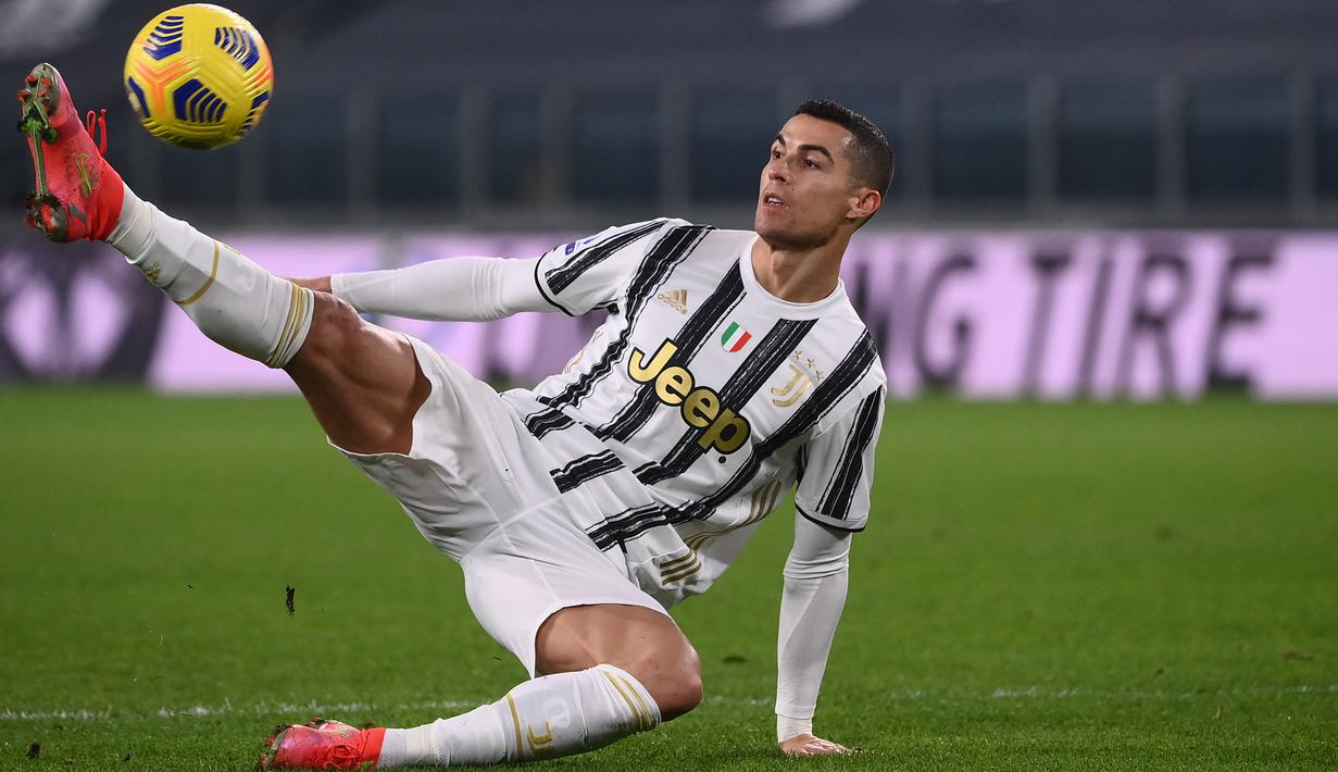 Penyerang Juventus, Cristiano Ronaldo menendang bola setelah kehilangan keseimbangan saat menghadapi Crotone dalam lanjutan Liga Italia di Allianz Stadium, Selasa dinihari (23/2/2021). Ronaldo menyumbang dua gol pada laga ini, sedangkan satu gol lagi disumbang Weston McKennie. (Marco BERTORELLO/AFP)