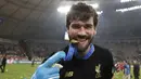 Kiper Liverpool, Alisson mengigit medali usai pertandingan melawan Flamengo pada final Piala Dunia Antarklub 2019 di Stadion Internasional Khalifa di Doha, Qatar (22/12/2019). Liverpool menang 1-0 atas Flamengo berkat gol tunggal Roberto Firmino di menit ke-99. (AP Photo/Hassan Ammar)