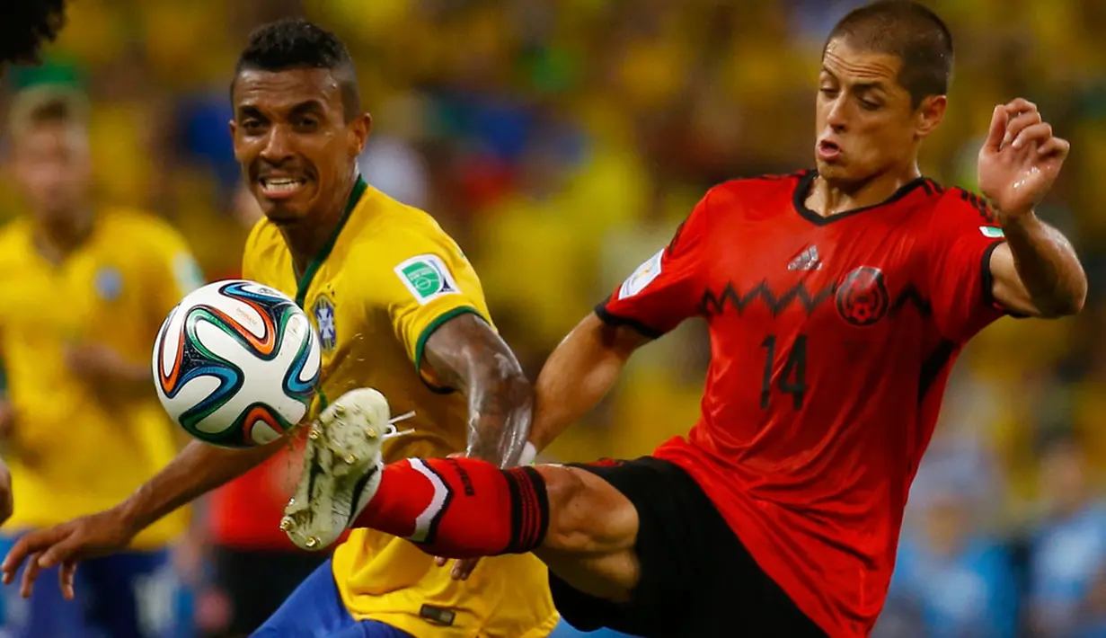 Pemain depan Meksiko, Javier Hernandez (kanan), berusaha merebut bola dari Luiz Gustavo (Brasil) saat berlaga di babak penyisihan Piala Dunia Grup A di Estadio Castelao, Brasil, (18/6/2014). (REUTERS/Kai Pfaffenbach)