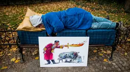 Aktivis tidur di bangku taman di pusat kota Bratislava untuk mengekspresikan solidaritas kepada tunawisma di Hungaria, 8 November 2018. Pasalnya tidur di tempat umum dilarang setelah undang-undang tunawisma diadopsi oleh pemerintah. (VLADIMIR SIMICEK/AFP)