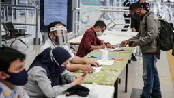 Calon penumpang melapor kepada petugas di Stasiun Pasar Senen, Jakarta, Jumat (10/7/2020). PT KAI telah mengoperasikan lima perjalanan kereta jarak jauh untuk tujuan Bandung, Cirebon, dan Surabaya mulai Jumat 10 Juli 2020. (Liputan6.com/Faizal Fanani)