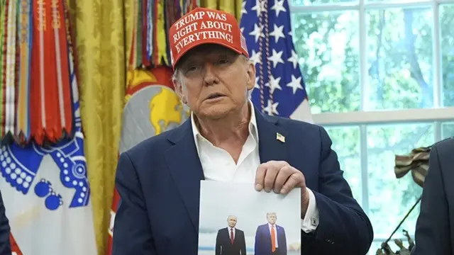 Presiden Donald Trump memperlihatkan sebuah foto dirinya bersama Presiden Rusia Vladimir Putin di Oval Office, Gedung Putih, Washington, Jumat (22/8/2025).
