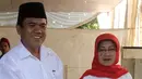 Calon Walikota Tangerang Selatan nomor urut 2 Arsid dan istri memasukan surat suara ke kotak saat menggunakan hak pilih di TPS 31 Kelurahan Pondok Benda, Tangsel, Rabu (9/12). Arsid merupakan pemilih perdana pada TPS tersebut. (Liputan6.com/Fery Pradolo)
